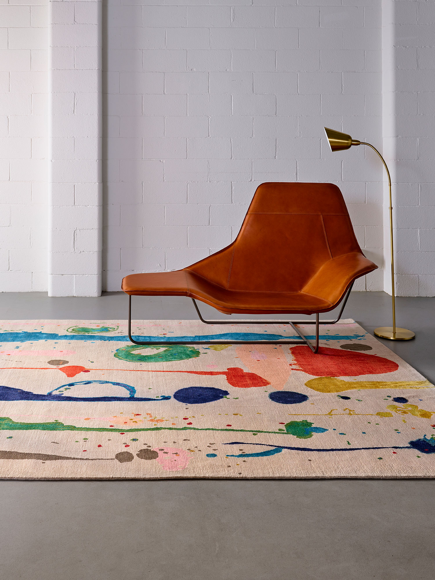 A colourful Zoya rug beside an orange chair
